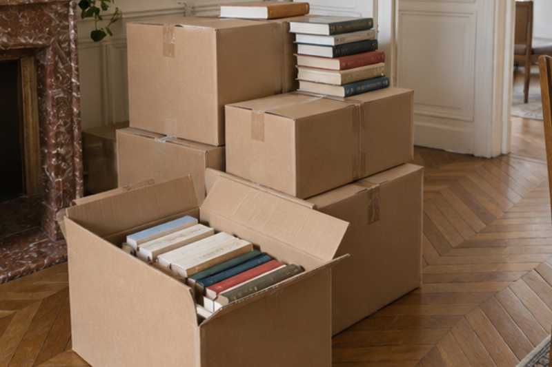 Petits cartons de livres fermés et empilés, des livres à ne plus savoir où les mettre