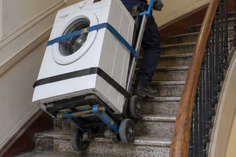 Lave-linge sanglé sur un diable dans un escalier, de l'électroménager et pas d'ascenseur adapté